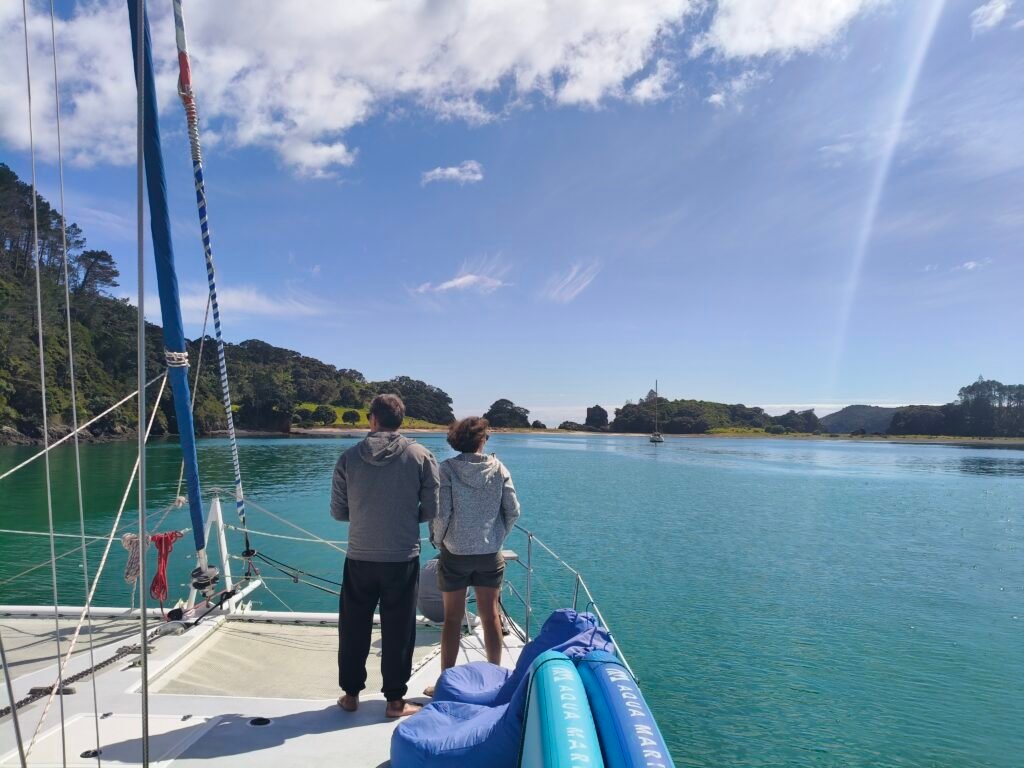 a couple take in views of a scenic bay while on a sailing charter in the Bay of Islands