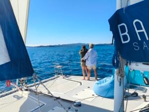 Catamaran sailing charter in the Bay of Islands with guests relaxing and enjoying scenic views on deck