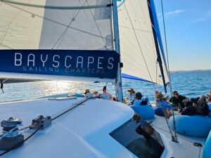 Catamaran sailing charter in the Bay of Islands with guests relaxing on deck