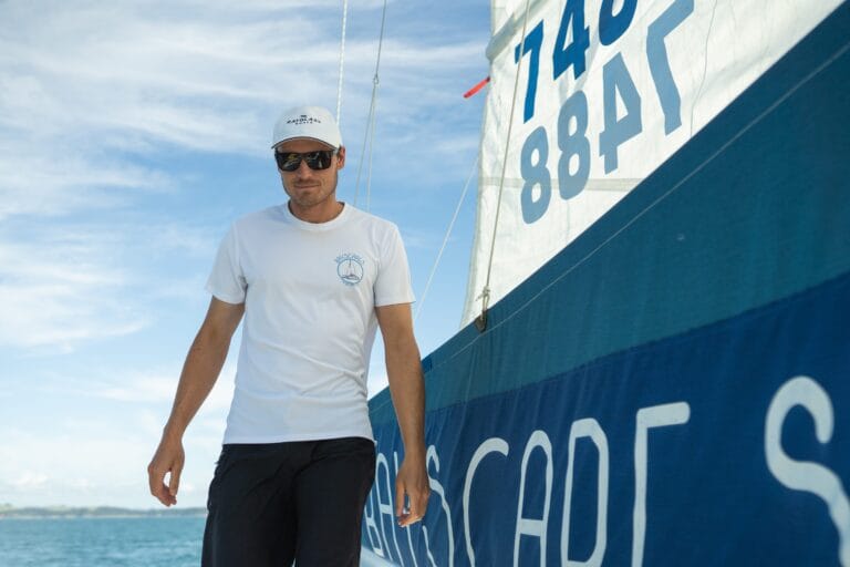A crew member from Basycapes Sailing Charters walks on a boat, assisting with the sails during a sailing trip.