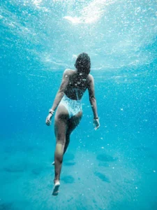 A person swimming in the Bay of Islands off a catamaran tour.