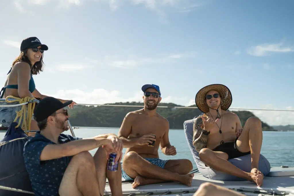 Guests Relaxing on beanbags and the deck of a sailing catamaran in the Bay of Islands